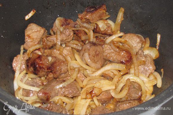 Добавьте к мясу лук и обжарьте, помешивая, до светло-желтого цвета.