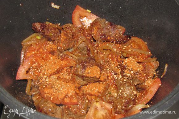 Положите помидоры. Во время их обжарки добавьте смесь специй, убавьте немного огонь. Потушите мясо с луком и помидорами, 5 минут.