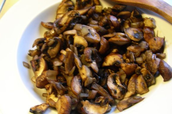Разогрейте 1 ст. л. оливкового масла и обжарьте лук и грибы без крышки минут 12–15 до испарения всей жидкости. Переложите смесь в отдельную тарелку.