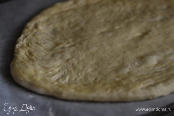 Присыпьте немного муки на тесто, руками сформируйте большой овал. Кисточкой смазать слегка оливковым маслом.