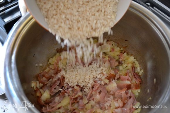 Слегка дать зарумяниться бекону (грудинке) и всыпать рис. Перемешать и дать пару минут рису пропитаться ароматами...