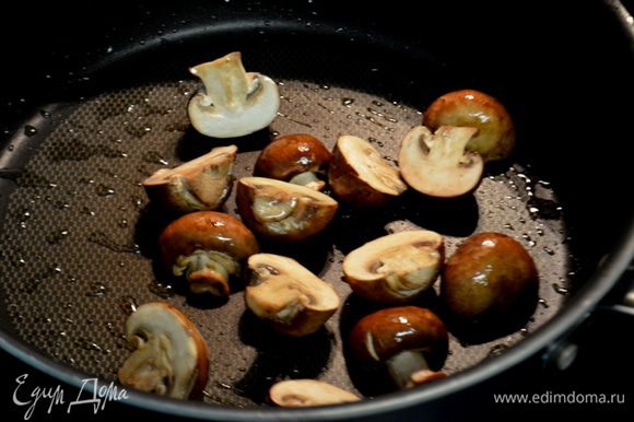 Разогреть на сковороде средне-высоком огне 2 стол.л оливковое масло. Добавить грибы и обжаривать примерно 7 мин. Посолить и поперчить. Переложить на тарелку.