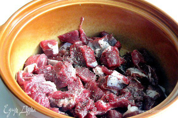Мясо нарезать небольшими кубиками, уложить на дно горшка или керамической формы с крышкой, посолить, поперчить.
