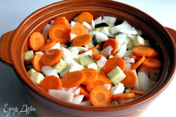 Поместить на мясо картофель, баклажаны, морковь и лук.