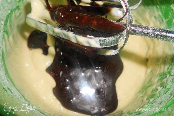В миску с мукой влить треть жидкой массы, перемешать, добавить растопленный шоколад, перемешать до однородности, добавить ягодный сироп.