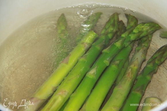 Подрезать кончики стеблей спаржи и отварить в течение 5 минут в кипящей подсоленной воде. Спаржу добавить к овощам и перемешать.
