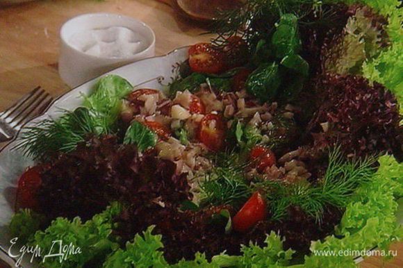 Подготовить салатный микс, выложить на блюдо, нарезать помидоры черри, полить 3/4 соусa, посолить и поперчить.