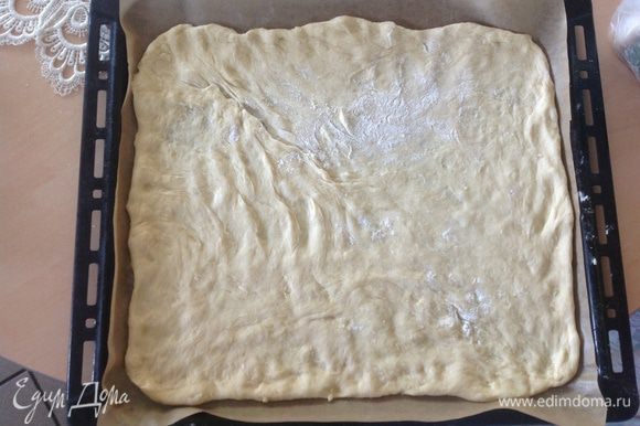 Тесто (половину от подошедшего) распределить на пергаментной бумаге, довольно тонко. Я это делаю пальцами, как для пиццы.