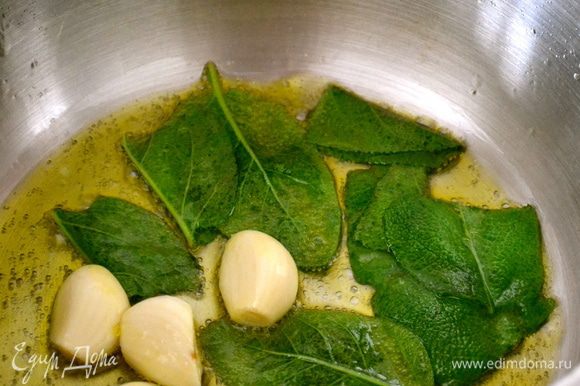 В глубокой широкой кастрюльке поставить обжариваться в оливковом масле целые зубчики чеснока и листья шалфея.