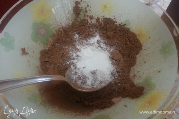 Затем постепенно просеиваем к яичной массе какао с разрыхлителем и крахмалом. Аккуратно смешиваем ингредиенты ложкой.