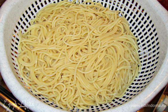 Готовые спагетти отбросьте на дуршлаг.