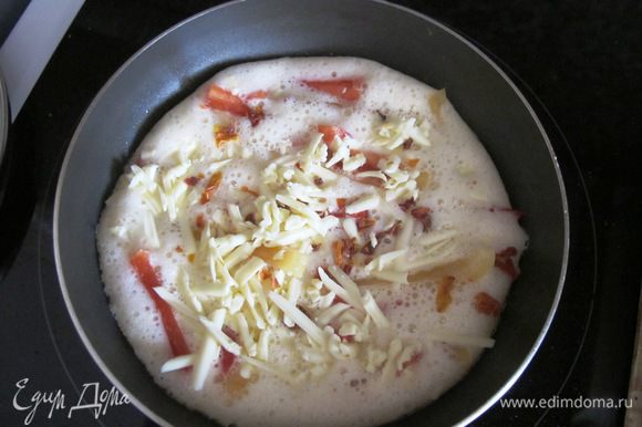 Нагреть сковороду, растопить маленький кусочек масла. Вылить омлетную смесь, выложить паприку, посыпать сыром, добавить сушеные томаты. Солить не надо, сыр отдаст свою соль и этого будет достаточно.