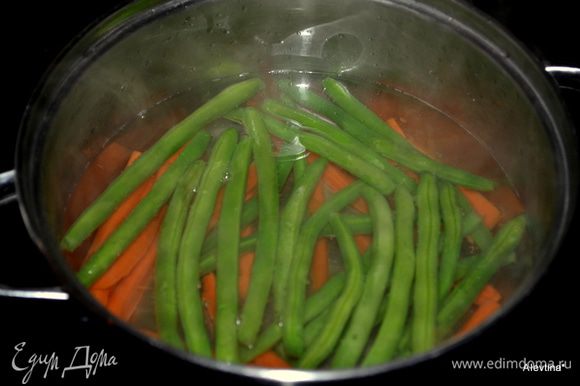 Зеленую фасоль и морковь положить в кастрюлю с горячей водой, чтоб вода лишь накрыла овощи. Варим до мягкого состояния фасоль и морковь,примерно 5-8 мин. под закрытой крышкой. Затем воду слить.