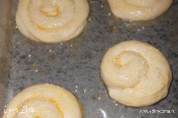 Смазать булочки яйцом и посыпать кунжутом. Подготовленные плюшки с корицей уложить на смазанный противень, дать немного постоять (15-20 мин).