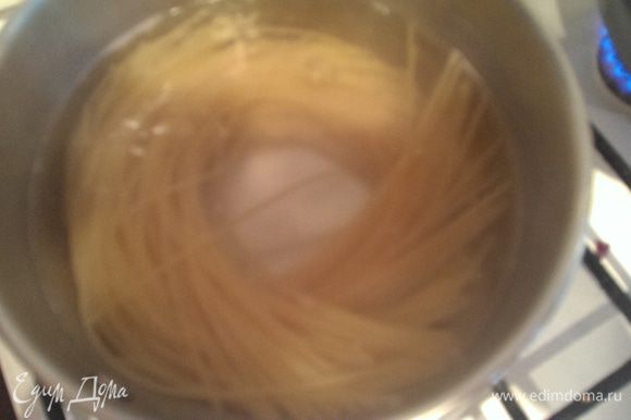 В кастрюлю с кипящей подсоленной водой положить спагетти, довести до кипения и варить ~8-10 минут. Готовые спагетти откинуть на дуршлаг.