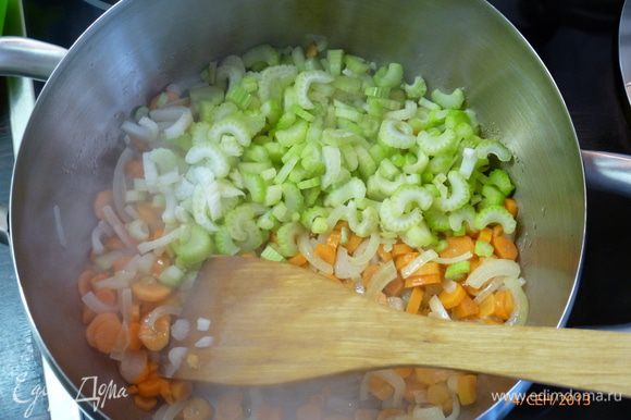 В это время нарезаем небольшими кубиками морковь и сельдерей. Отправляем их в кастрюлю с луком. Пассеруем 5 минут.