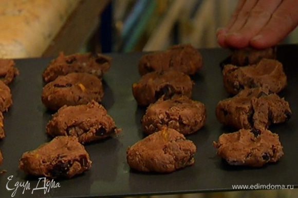 Охлажденное печенье вынуть из холодильника, слегка прижать шарики руками, чтобы получились лепешки, и выпекать в разогретой духовке 15–17 минут.
