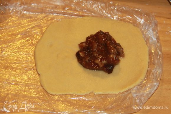 Поскольку тесто очень нежное, пришлось делать пирожки с помощью пищевой плёнки. Каждый кусочек теста раскатываем в круг диаметром 6-8 см, кладём начинку.