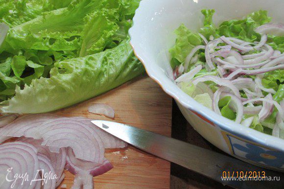 Салат вымыть, обсушить, крупно нарвать и поместить в салатницу. Лук нарезать тонкими полукольцами. Добавить лук и вермишель в салат.