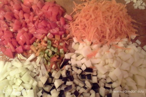 Режем овощи:лук, цукини, баклажан, перец кубиком. Морковь трем на терке. Помидоры обдаем кипятком и снимаем кожицу, режем кубиком. Чеснок мелко нарезаем.