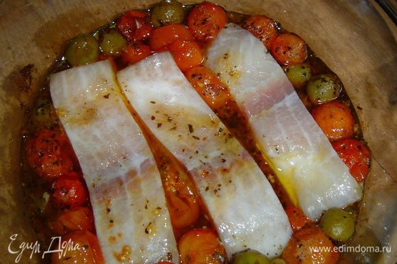 Достаем помидорно-оливковую смесь из духовки, томаты раздвигаем, а в середину выкладываем кусочки рыбного филе,
