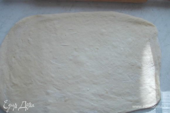 Когда тесто подойдет в два раза, поделим его на две части. Каждую часть раскатываем в прямоугольник.