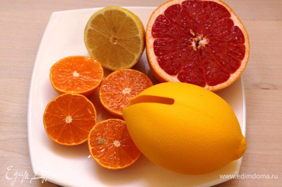 Выжать сок из лимона, мандарина и грейпфрута.