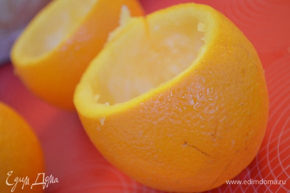 У апельсинов срезать верхушки. Мякоть убрать большой ложкой так, чтобы не повредить кожуру.