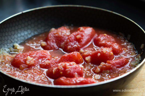 Добавить в сковороду томаты вместе с соком. Немного размять их лопаткой.
