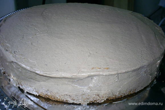 Теперь кладем оставшийся пласт бисквита, срезом на крем. Таким образом верхом торта стало дно бисквита. Обмазываем верх и бока торта шоколадным кремом.