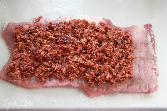 Подготовленный пласт свинины посолить, поперчить, выложить начинку, не выкладывая до края на 3 см.