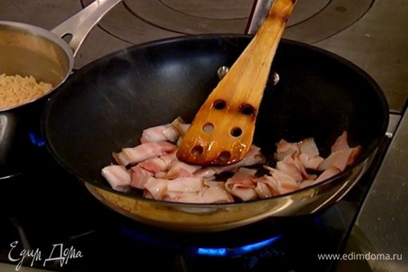 Разогреть в сковороде вок 1 ч. ложку оливкового масла, обжарить бекон, затем выложить его на бумажное полотенце, чтобы удалить излишки жира.