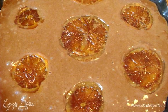 Вылить тесто в смазанную маслом форму. Сверху выложить карамелизированные апельсины. Поставить в разогретую до 180°С духовку примерно на 35 минут. Готовность проверять деревянной шпажкой. Она должна оставаться сухой при протыкании теста.