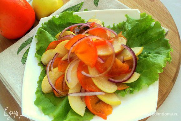 На блюдо выложить листья салата. Сверху разложить пластинки яблока и хурмы, чередуя их, и полукольца лука. Сверху полить соусом. Приятного аппетита!