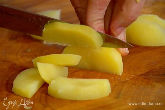 Картофель отварить в мундире, затем почистить и нарезать дольками.