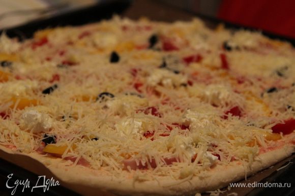 Посыпать пиццу сырной смесью и кунжутным семенем.