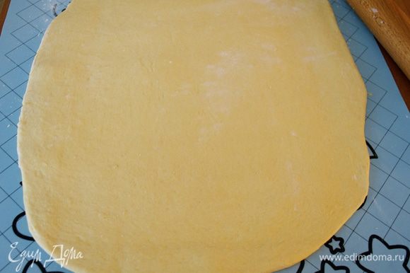 По истечение указанного времени достать тесто из миски, выложить на слегка припыленную мукой поверхность и раскатать в пласт толщиной 3-4 мм.
