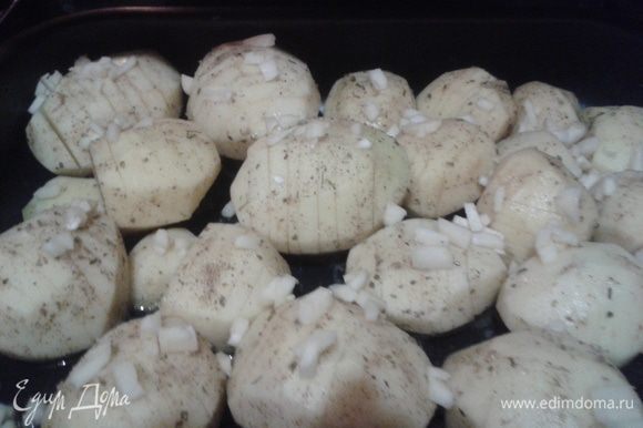 Посыпать картофель чесноком и поставить в разогретую до 180 градусов духовку.