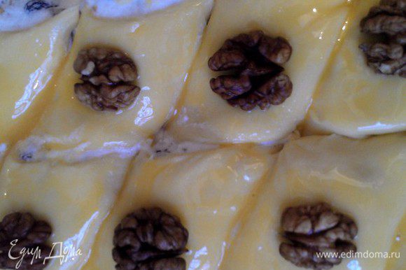 На последний слой теста начинка не требуется. В сыром виде полученную пахлаву нужно осторожно разрезать на порционные кусочки и покрыть оставшимся 1 взбитым желтком поверхность. По желанию можно украсить сверху орешками.