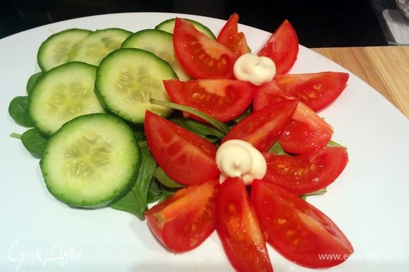 Готовим тарелочку - выкладываем листья шпината, резаные огурчики и помидорчики.
