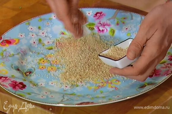 Небольшую часть сухарей высыпать на тарелку, добавить кунжутное семя и перемешать.