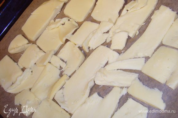 Разогреть духовку до 200°. Нарезать сыр произвольно, если у вас сыр уже порезан, советую разложить его в 2 или 3 слоя на противень, выстланный бумагой.