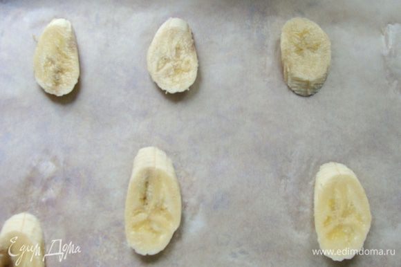 Банан порезать дольками, выложить на противень, застеленный пекарской бумагой, на довольно большом расстоянии друг от друга.