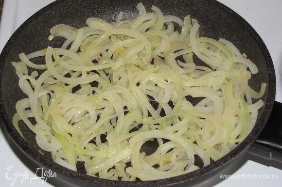 Добавить в сковороду 1 ст. л. оливкового масла и обжарить лук, нарезанный тонкими полукольцами.