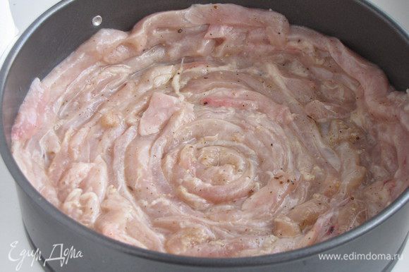Форму (20 см) смазать растительным маслом. Уложить полоски мяса на дно и по бокам. Укладывать по спирали в один слой.