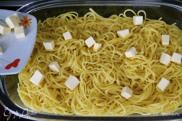 Сливочное масло порезать маленькими кубиками и, как только паста полностью остынет, добавить к спагетти и перемешать.