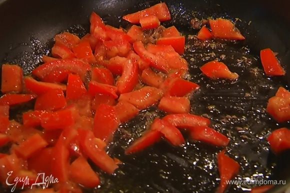 Чашечки помидоров нарезать небольшими кубиками и добавить в сковороду с анчоусами, поперчить и перемешать — помидоры должны слегка поплыть, но остаться упругими.