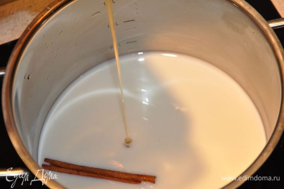 В кастрюльку влить молоко, добавить палочку корицы. Налить мед и насыпать сахар. Влить ванильную эссенцию. Включить огонь.