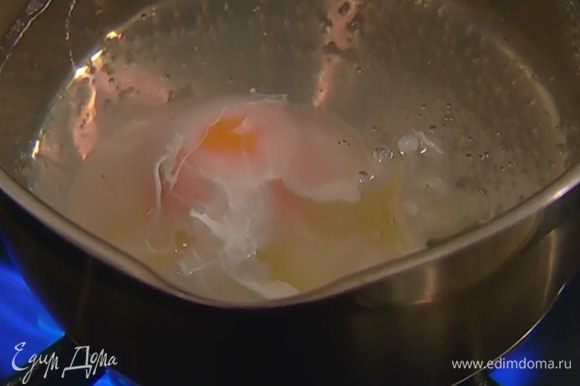 Приготовить яйцо пашот: в небольшой кастрюле вскипятить 500 мл воды, влить уксус, с помощью венчика сделать маленький водоворот и в центр воронки разбить яйцо. Убавить огонь и варить 2–3 минуты, затем шумовкой выложить яйцо на бумажное полотенце.