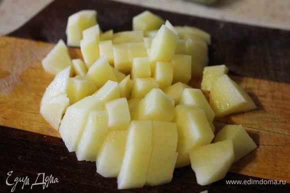 Картофель режем кубиком и кладем в бульон. Варим картофель 15 минут, потом добавляем рис.